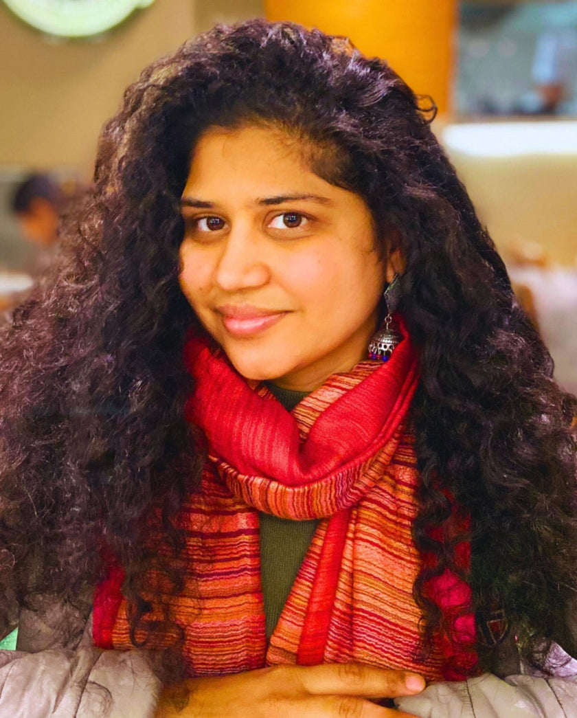 founder wearing a red scarf in an indoor setting
