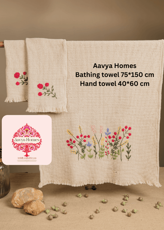 Two Aavya Homes bath towel and hand towel set with floral designs on a wooden rack.