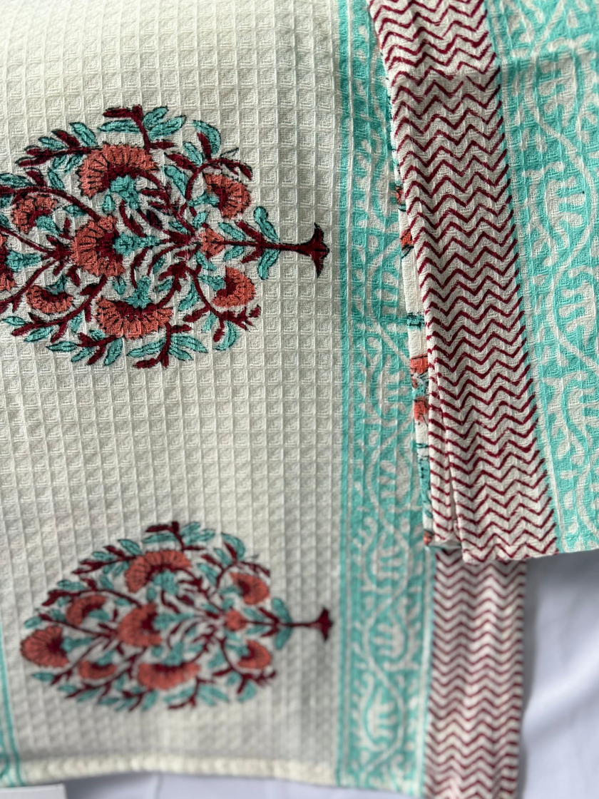 Textile with floral patterns and a striped border on a white background