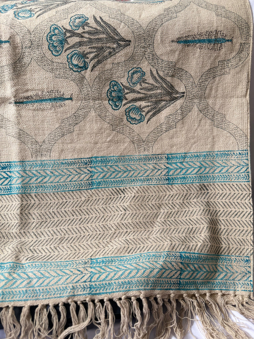 Textile with floral embroidery and blue patterns on a beige background