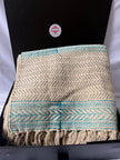 Textile with floral patterns and geometric designs in blue and beige.