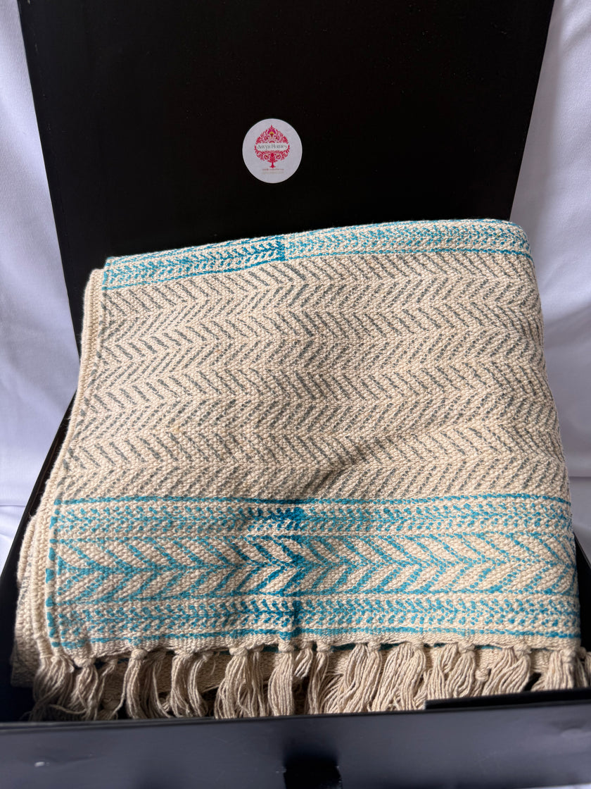 Textile with floral patterns and geometric designs in blue and beige.