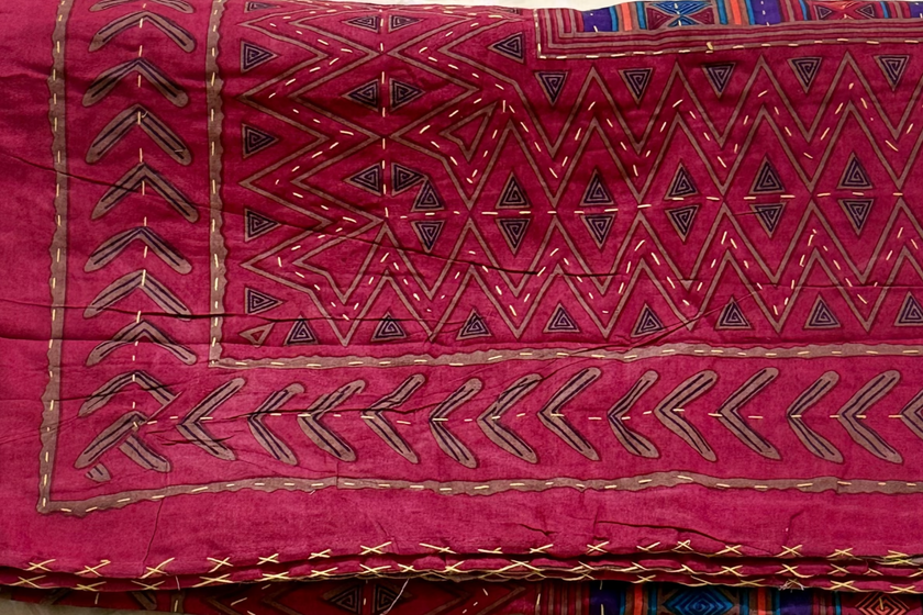 Red embroidered fabric on a white background with floral patterns